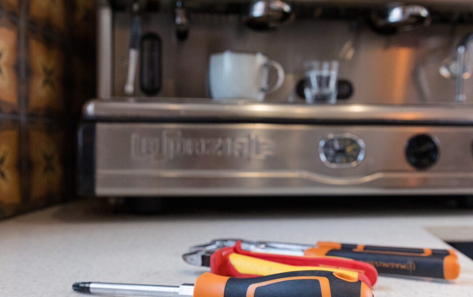 Coffee machine engineer tools in front of a commercial coffee machine