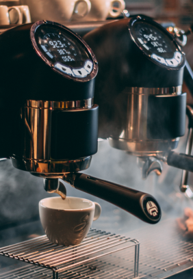 coffee machine dispensing a coffee surrounded by steam
