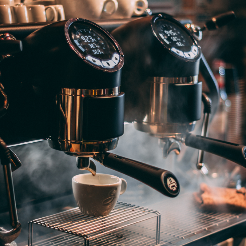 coffee machine dispensing a coffee surrounded by steam