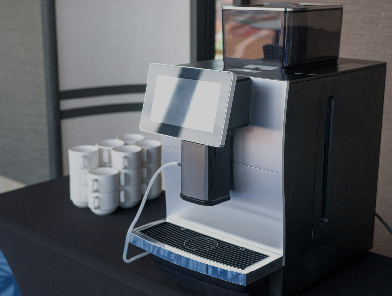 an automatic coffee machine on a table in a hotel room